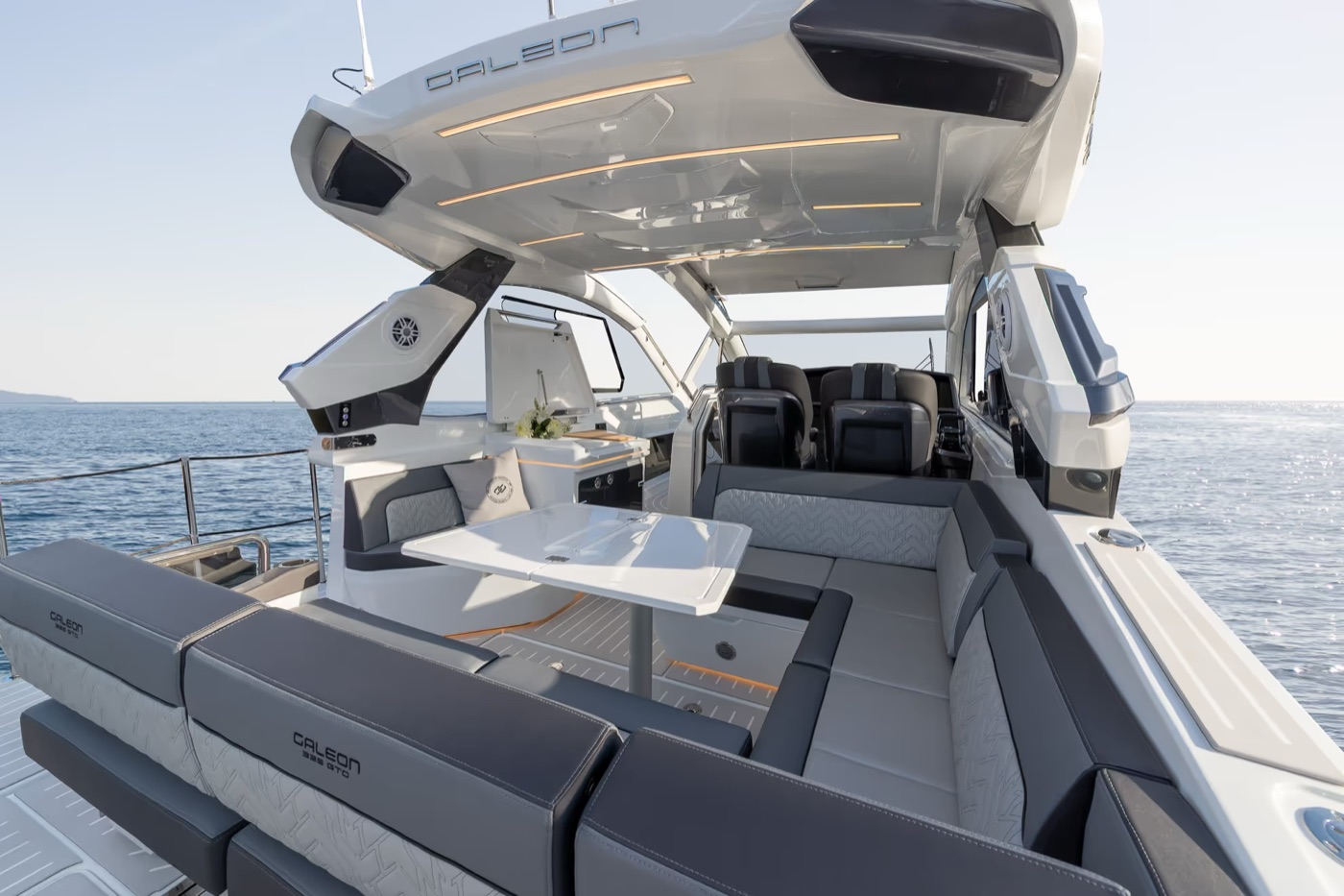 Open cockpit under the hardtop: wraparound settee, table and twin helm seats