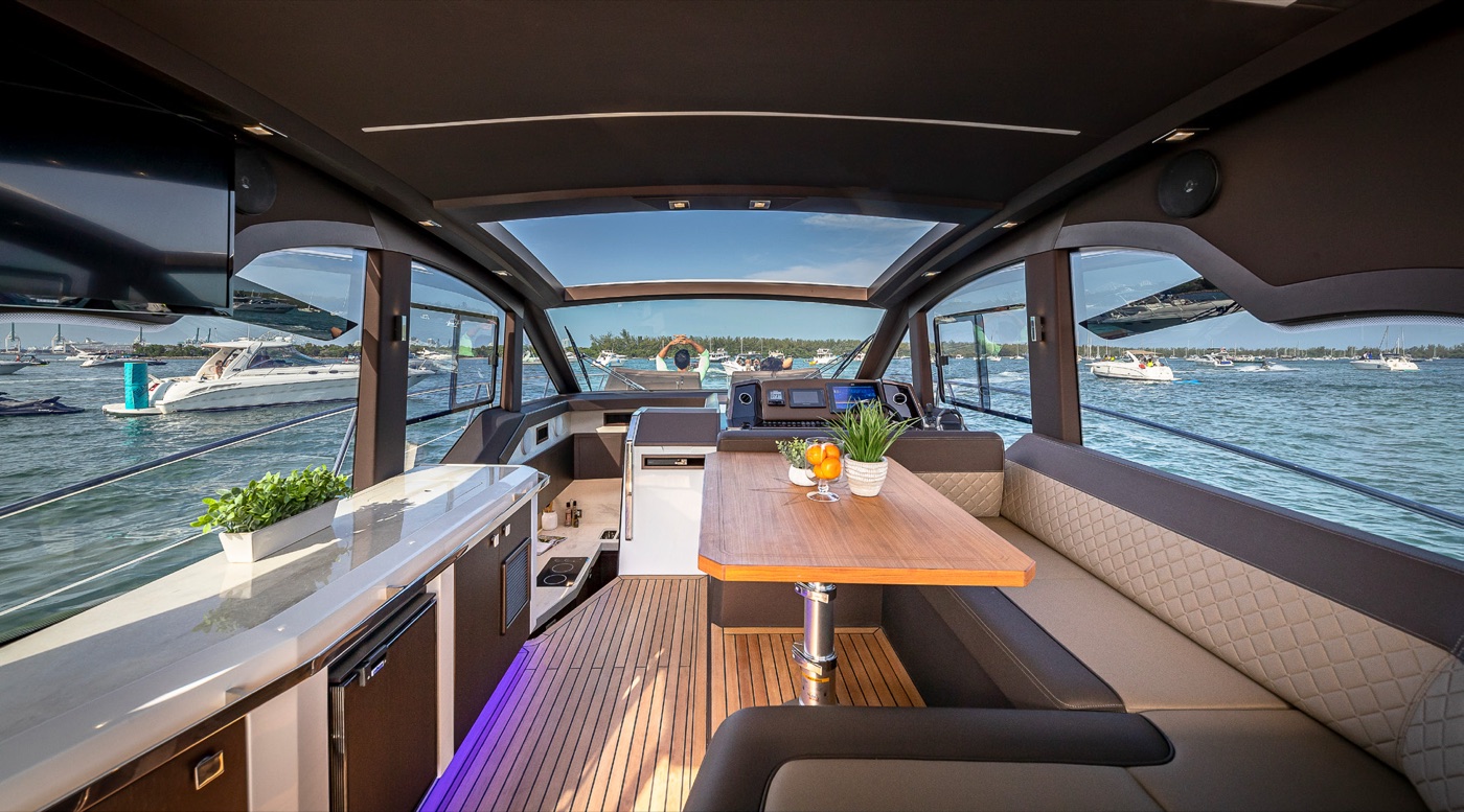 Main deck saloon with dinette, galley counter and forward helm, sunroof open