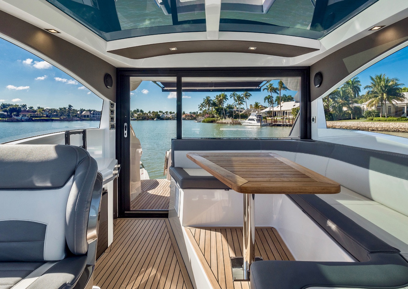 485 HTS saloon: L-shaped settee and teak table under the glass roof