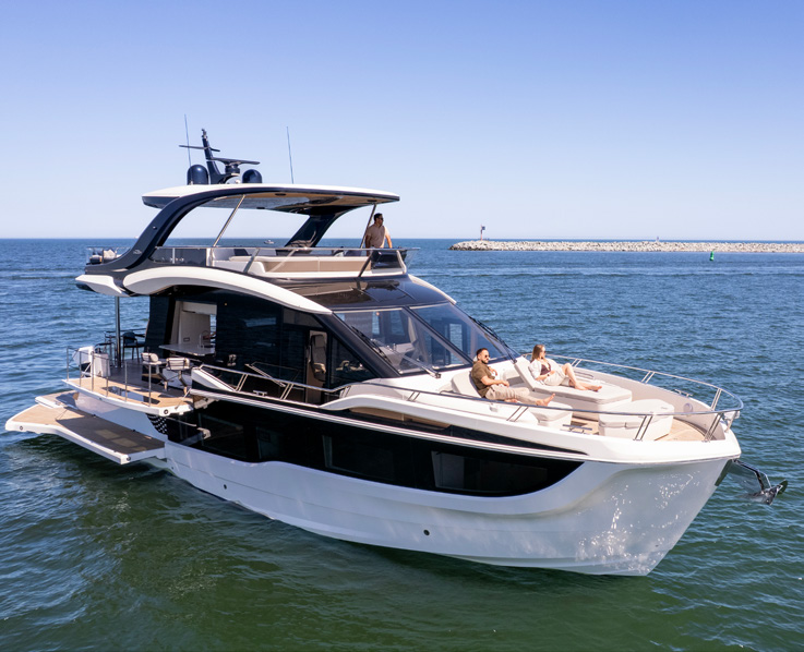 620 FLY at anchor with guests on the bow sunpads and flybridge