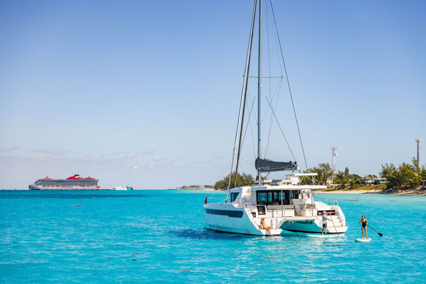 Leopard 52 at anchor in a turquoise bay, paddleboarding off the stern