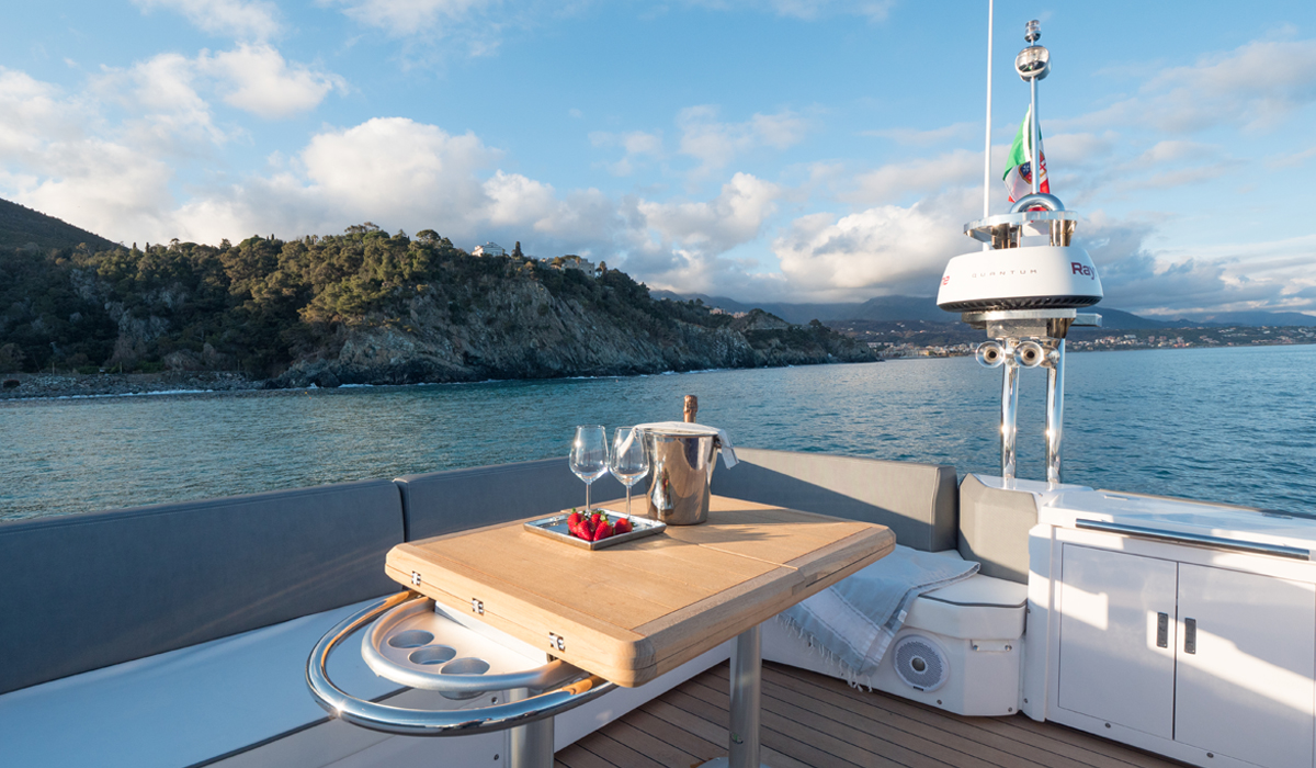 Champagne on the flybridge table, coastline beyond